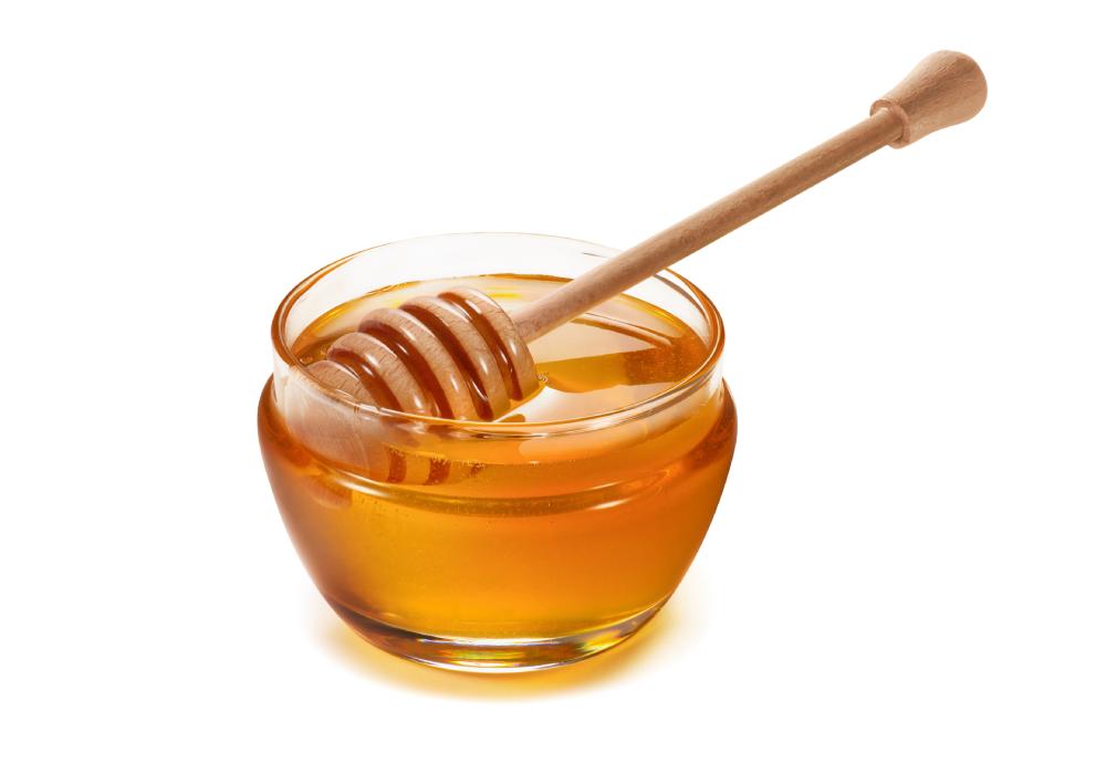 glass jar of honey isolated on a white background