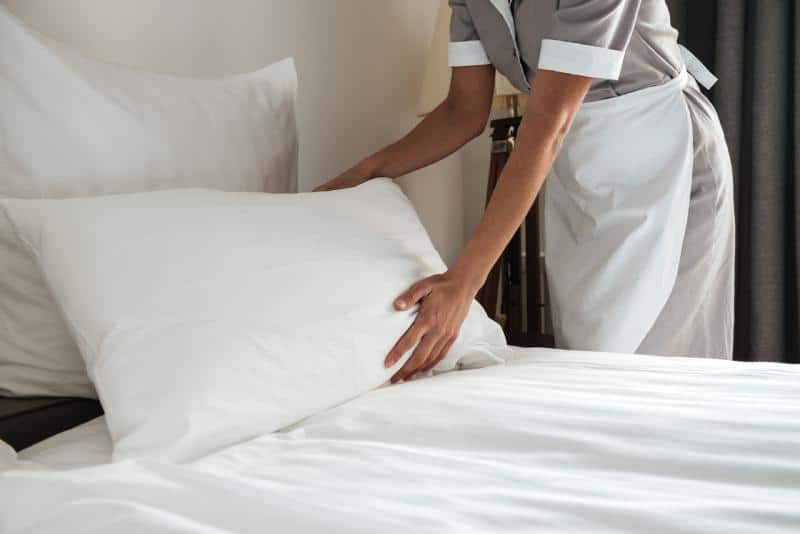 maid making a hotel bed