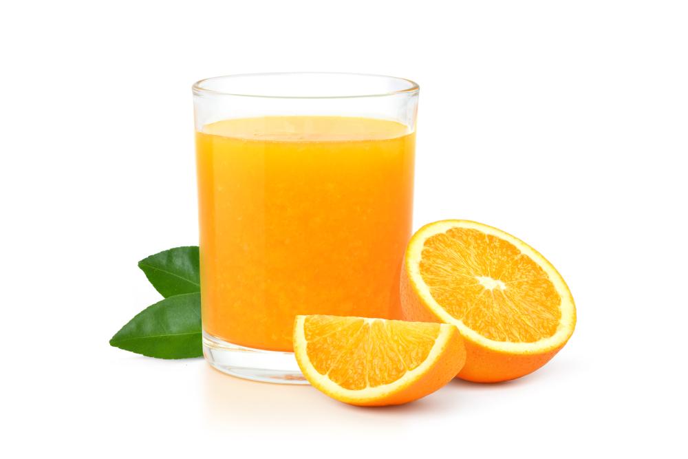 orange juice in a glass with slices of orange on the side isolated on a white background