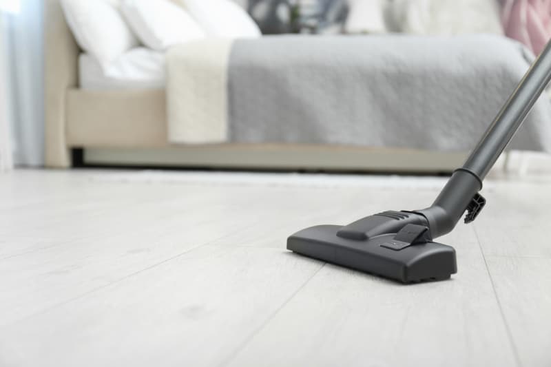 vacuuming a bedroom floor