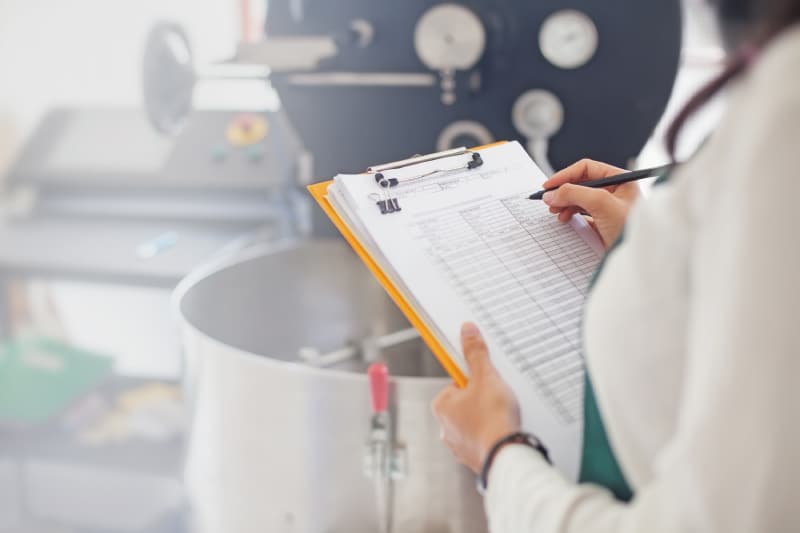 Inspector with a clipboard inspecting food facility